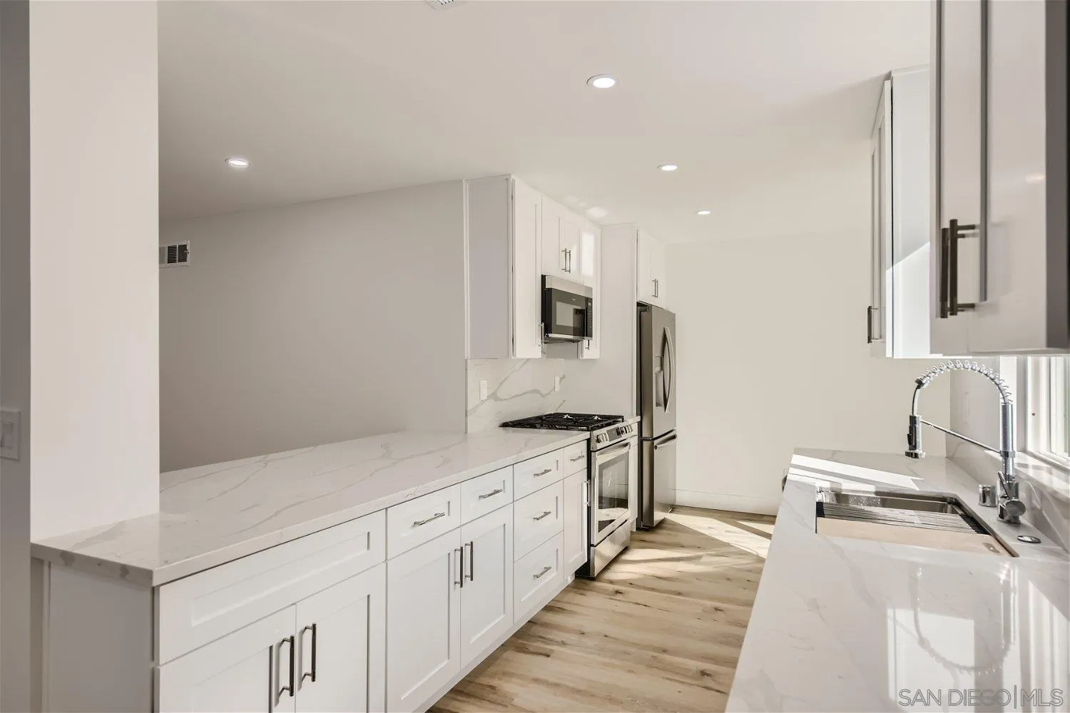 14222 Halper Road Poway, CA 92064 - Photo 8 of 30 a large white kitchen with stainless steel appliances
