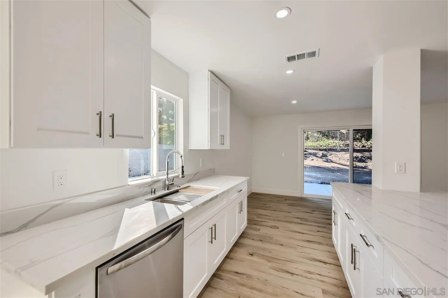 14222 Halper Road Poway, CA 92064 - Photo 9 of 30 a large white kitchen with kitchen island a sink stove and cabinets
