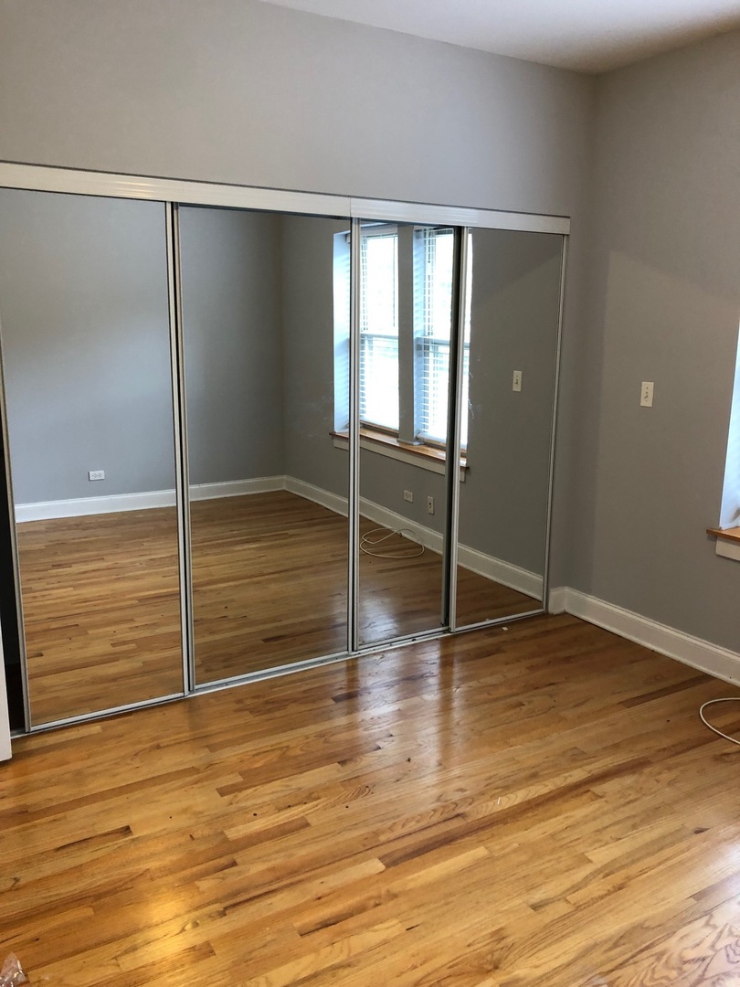 4855 North Drake Avenue, Unit 1 Chicago, IL 60625 - Photo 13 of 20 a view of an empty room with wooden floor and a window