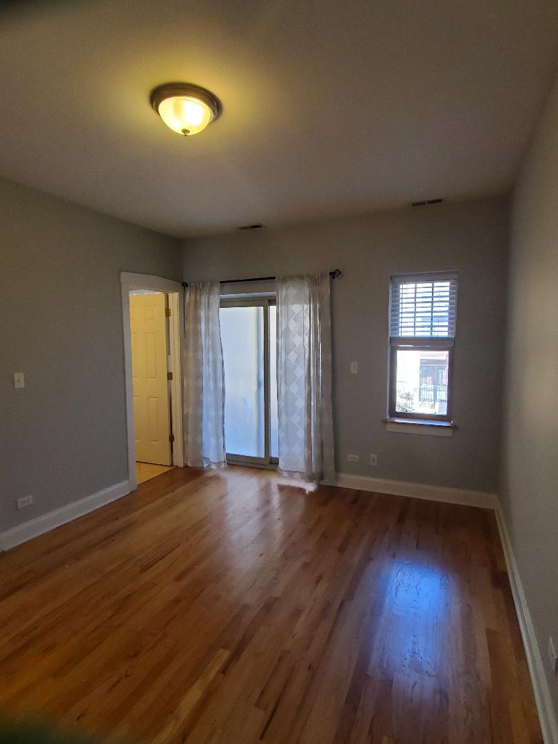 4855 North Drake Avenue, Unit 1 Chicago, IL 60625 - Photo 19 of 20 an empty room with wooden floor and windows