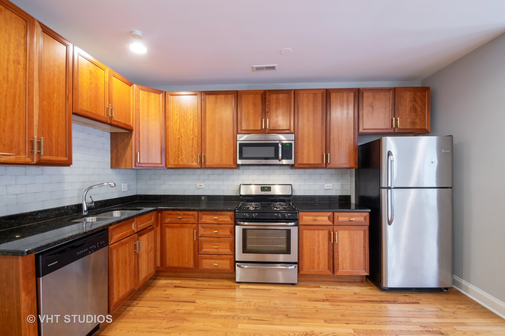 4855 North Drake Avenue, Unit 1 Chicago, IL 60625 - Photo 5 of 20 a kitchen with stainless steel appliances granite countertop a stove a sink dishwasher a refrigerator and a microwave