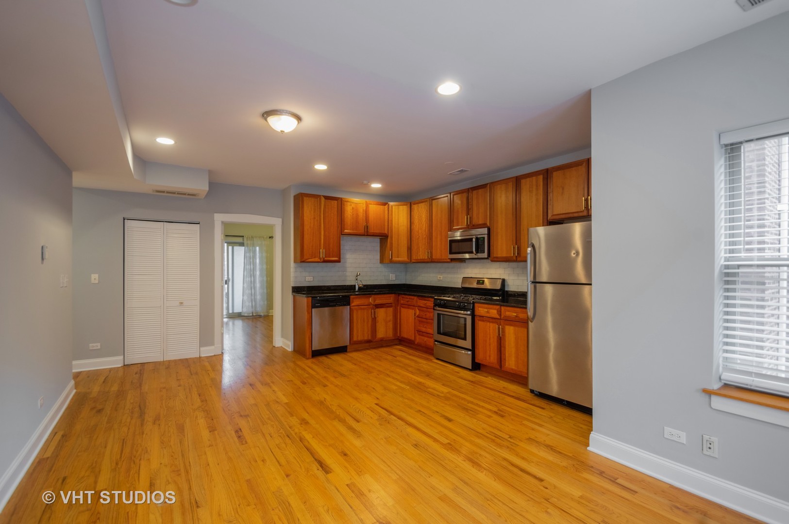 4855 North Drake Avenue, Unit 1 Chicago, IL 60625 - Photo 6 of 20 a open kitchen with stainless steel appliances granite countertop a stove a sink and a refrigerator with wooden floor