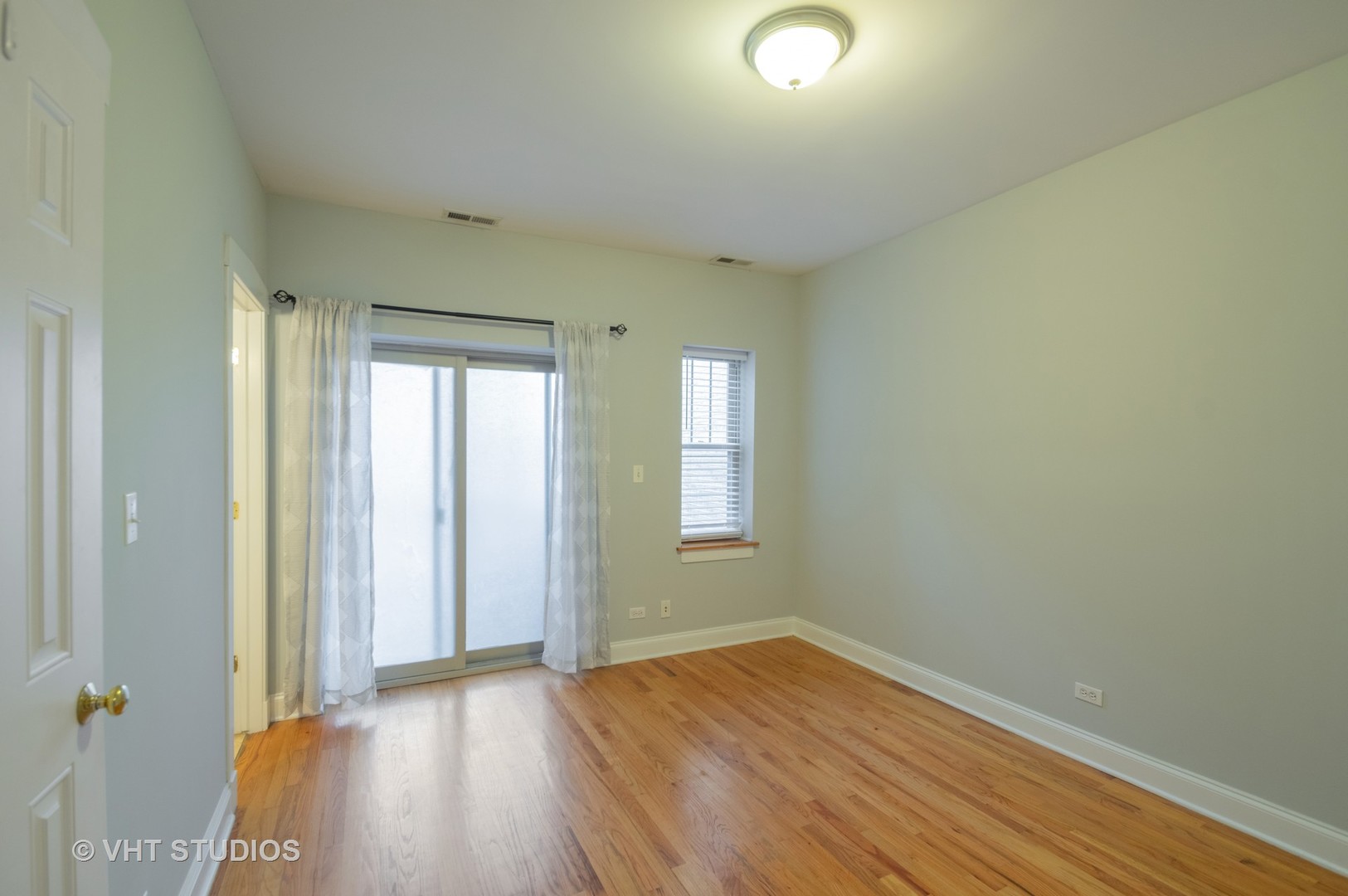 4855 North Drake Avenue, Unit 1 Chicago, IL 60625 - Photo 8 of 20 an empty room with wooden floor and windows