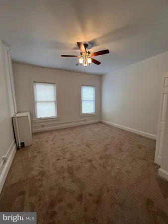 an empty room with closet and a ceiling fan