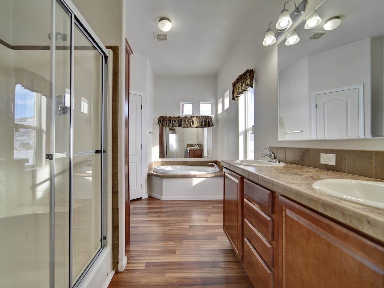 2423 16 Road Loma, CO 81524 - Photo 17 of 38 a bathroom with a granite countertop sink a large mirror and a shower