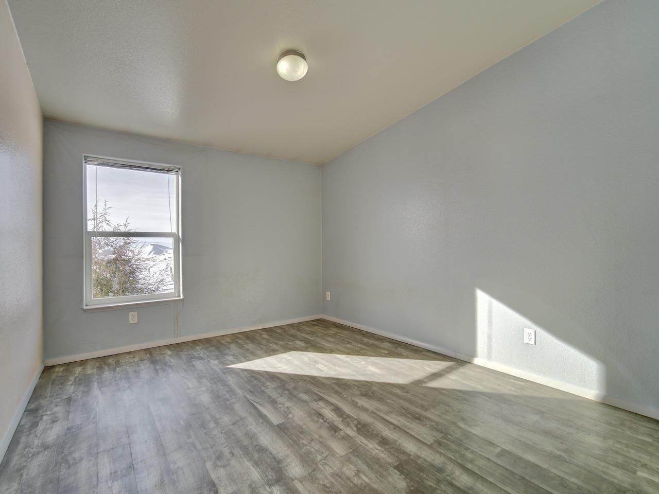 2423 16 Road Loma, CO 81524 - Photo 21 of 38 an empty room with wooden floor and windows