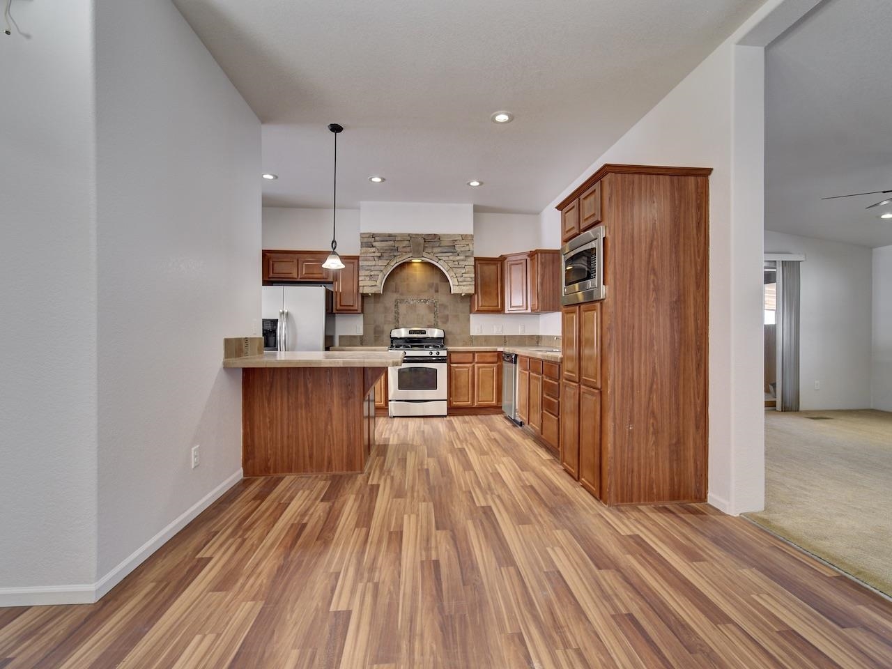 2423 16 Road Loma, CO 81524 - Photo 9 of 38 a kitchen with stainless steel appliances granite countertop a refrigerator a stove and a wooden floors