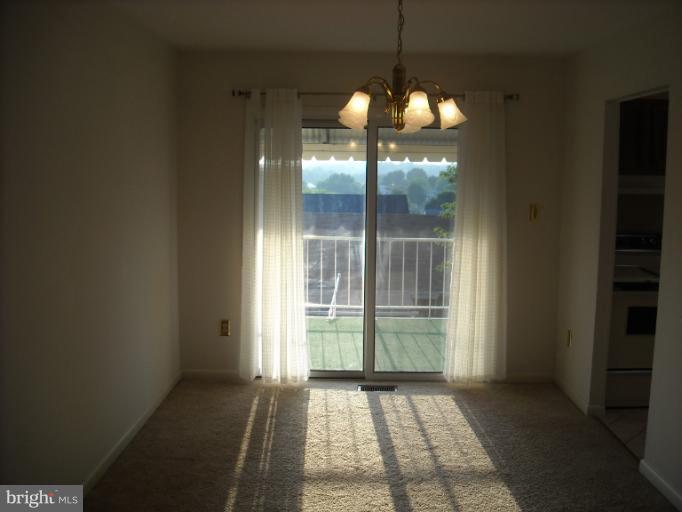 1215 Roxboro Road Rosedale, MD 21237 - Photo 12 of 29 an empty room with chandelier fan and windows