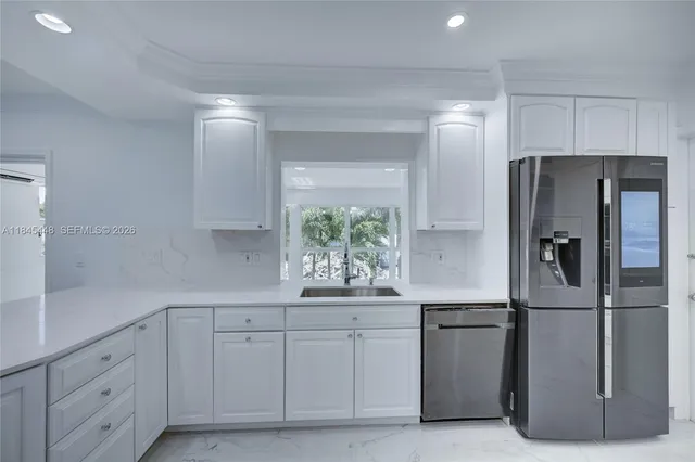 a kitchen with white cabinets and refrigerator