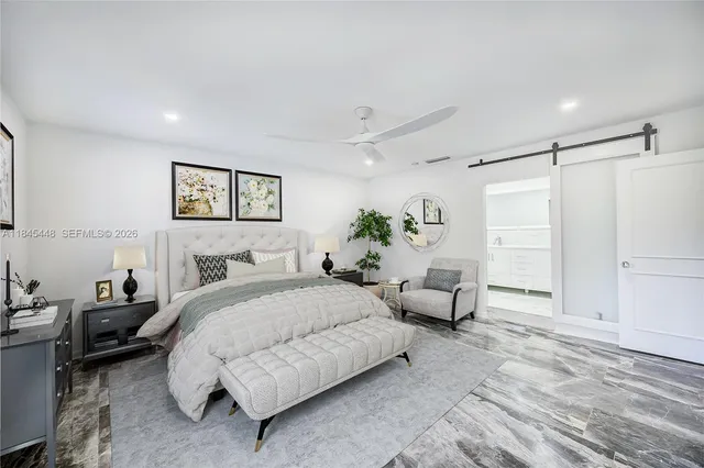 a spacious bedroom with a bed a couch and a window