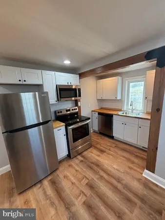 a kitchen with granite countertop a refrigerator stove and sink