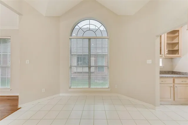 an empty room with cabinet and windows