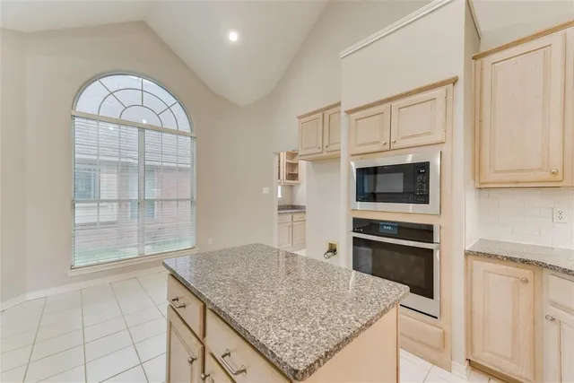 a kitchen with stainless steel appliances granite countertop a stove a microwave and a refrigerator