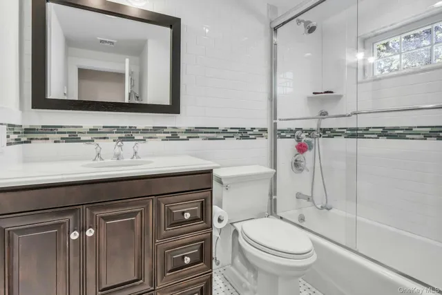 a bathroom with a granite countertop toilet sink and mirror
