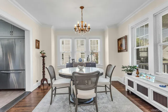 a dining room with furniture a chandelier and wooden floor