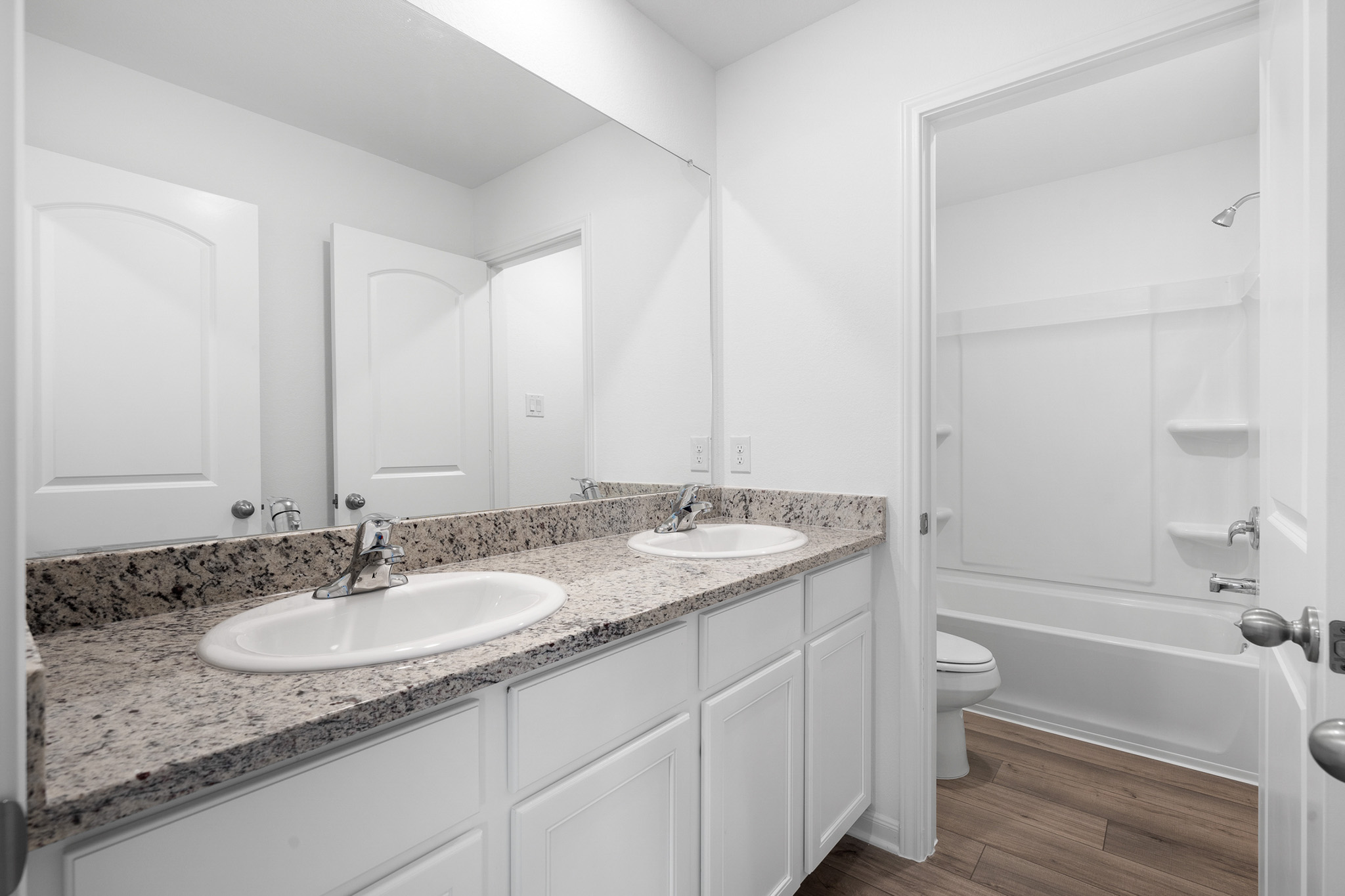 197 Fairlawn Way Maxwell, TX 78656 - Photo 11 of 14 Bathroom with double vanity, dark wood-style floors, and shower / tub combination