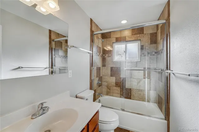 a bathroom with a bathtub shower sink vanity and toilet