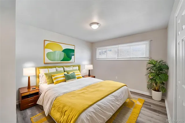 a bedroom with a bed and painting on the wall