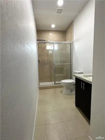 a bathroom with a granite countertop sink a toilet and shower