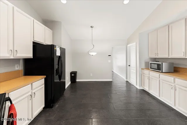a kitchen with granite countertop a refrigerator and a stove