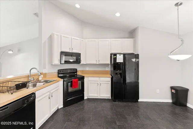 a kitchen with a refrigerator and a stove top oven