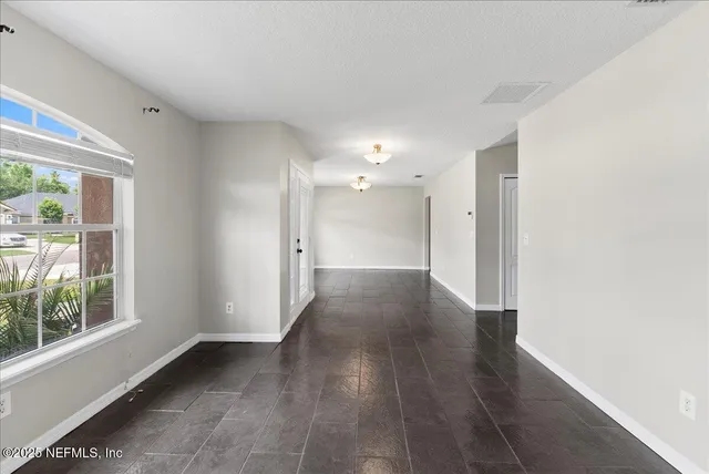 a view of a hallway with wooden floor and a window