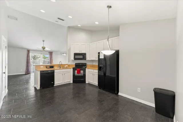 a kitchen with stainless steel appliances kitchen island granite countertop a refrigerator a stove top oven a sink and dishwasher