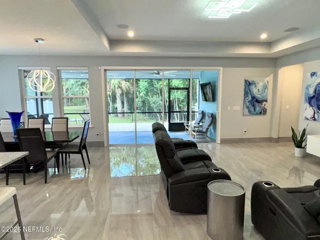a living room with stainless steel appliances furniture and a window