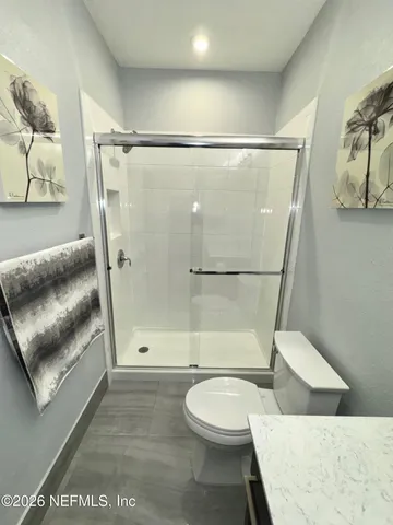 a view of a tennis ground with large trees