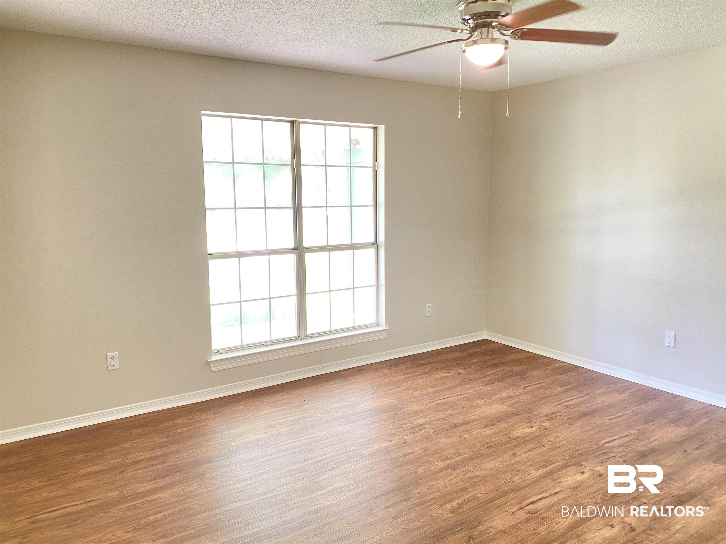 12150 Lee Bishop Road Irvington, AL 36544 - Photo 19 of 26 Empty room featuring baseboards, a textured ceiling, ceiling fan, and wood finished floors
