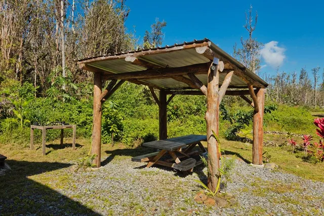 a view of backyard with a table and chairs under an umbrella