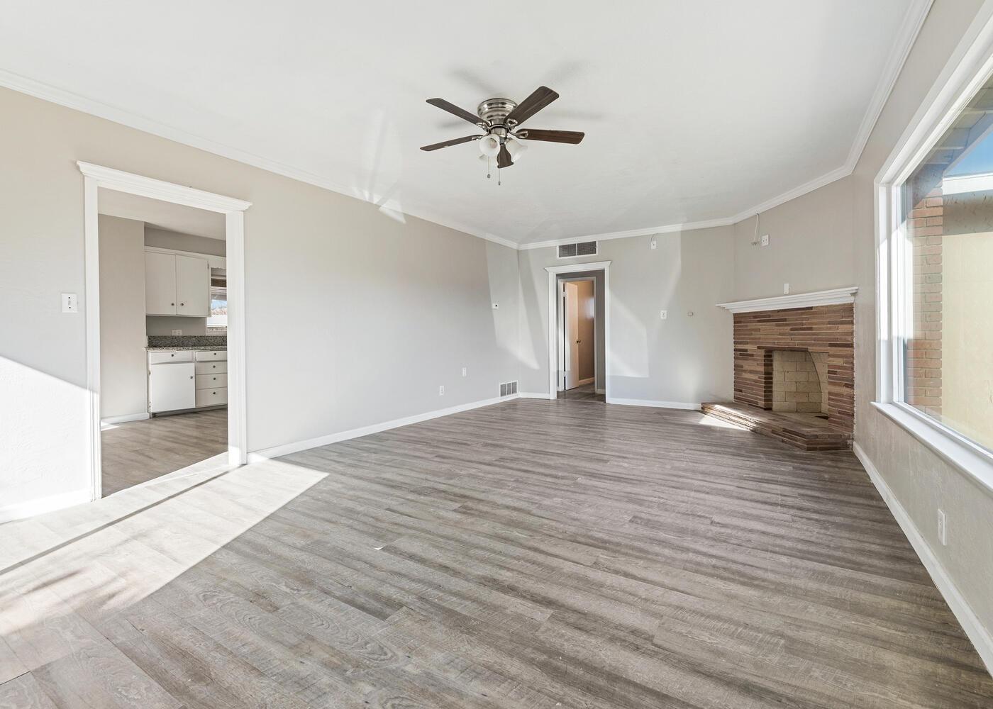1265 South Klein Avenue Reedley, CA 93654 - Photo 6 of 31 an empty room with wooden floor a ceiling fan and windows