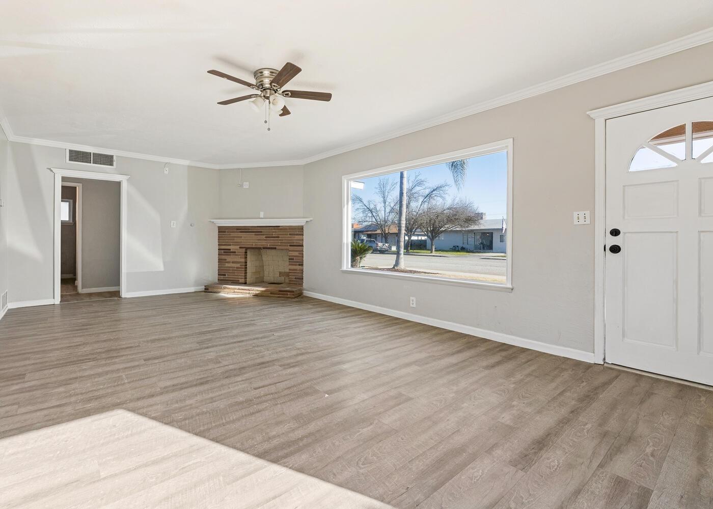 1265 South Klein Avenue Reedley, CA 93654 - Photo 7 of 31 wooden floor in an empty room with a fireplace
