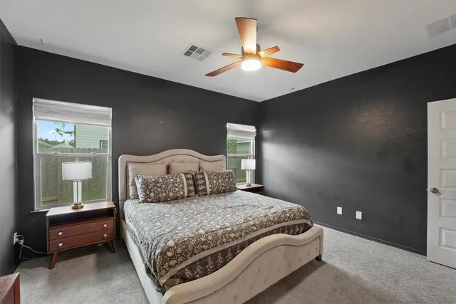a bedroom with a large bed and a chandelier