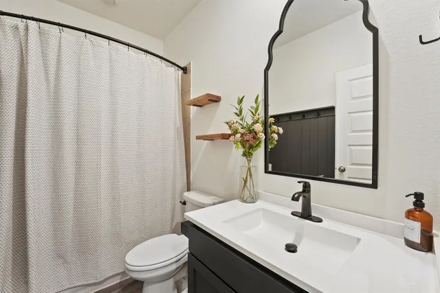 a bathroom with a sink a toilet and mirror