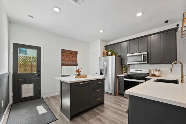 a kitchen with refrigerator cabinets and wooden floor