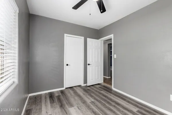 an empty room with ceiling fan and window
