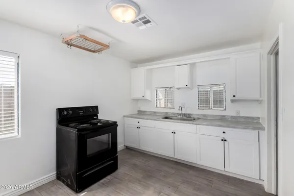 a kitchen with granite countertop a sink a stove and cabinets