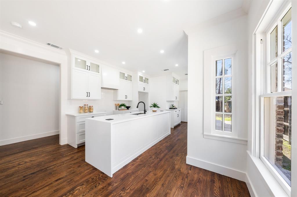 713 Ridgeway Street Dallas, TX 75214 - Photo 13 of 29 a large white kitchen with wooden floor and a window
