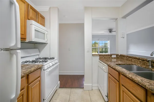 a kitchen with granite countertop a sink stove and cabinets