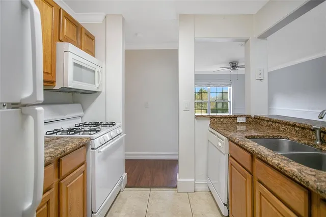 a kitchen with granite countertop a sink stove and cabinets