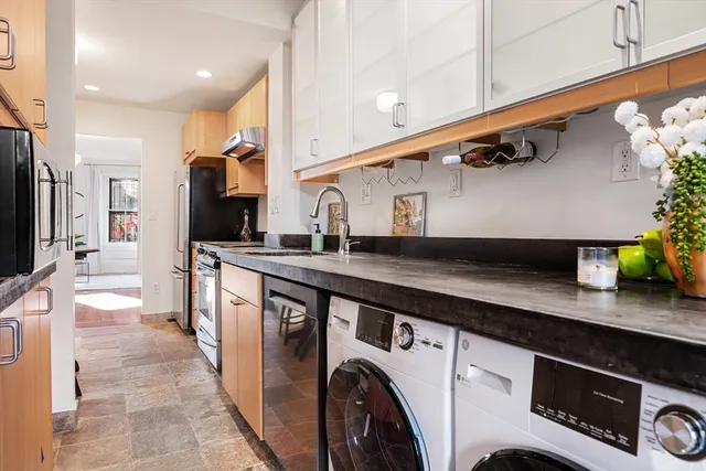 a kitchen with stainless steel appliances a sink a stove and cabinets