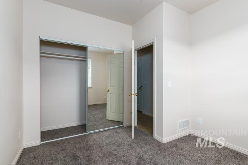 204 La Valle Strada Pocatello, ID 83201 - Photo 14 of 23 Unfurnished bedroom featuring dark colored carpet and a closet