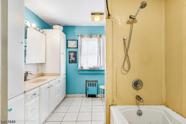 a bathroom with a tub sink a mirror and a shower