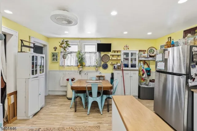 a kitchen with stainless steel appliances refrigerator dining table and chairs