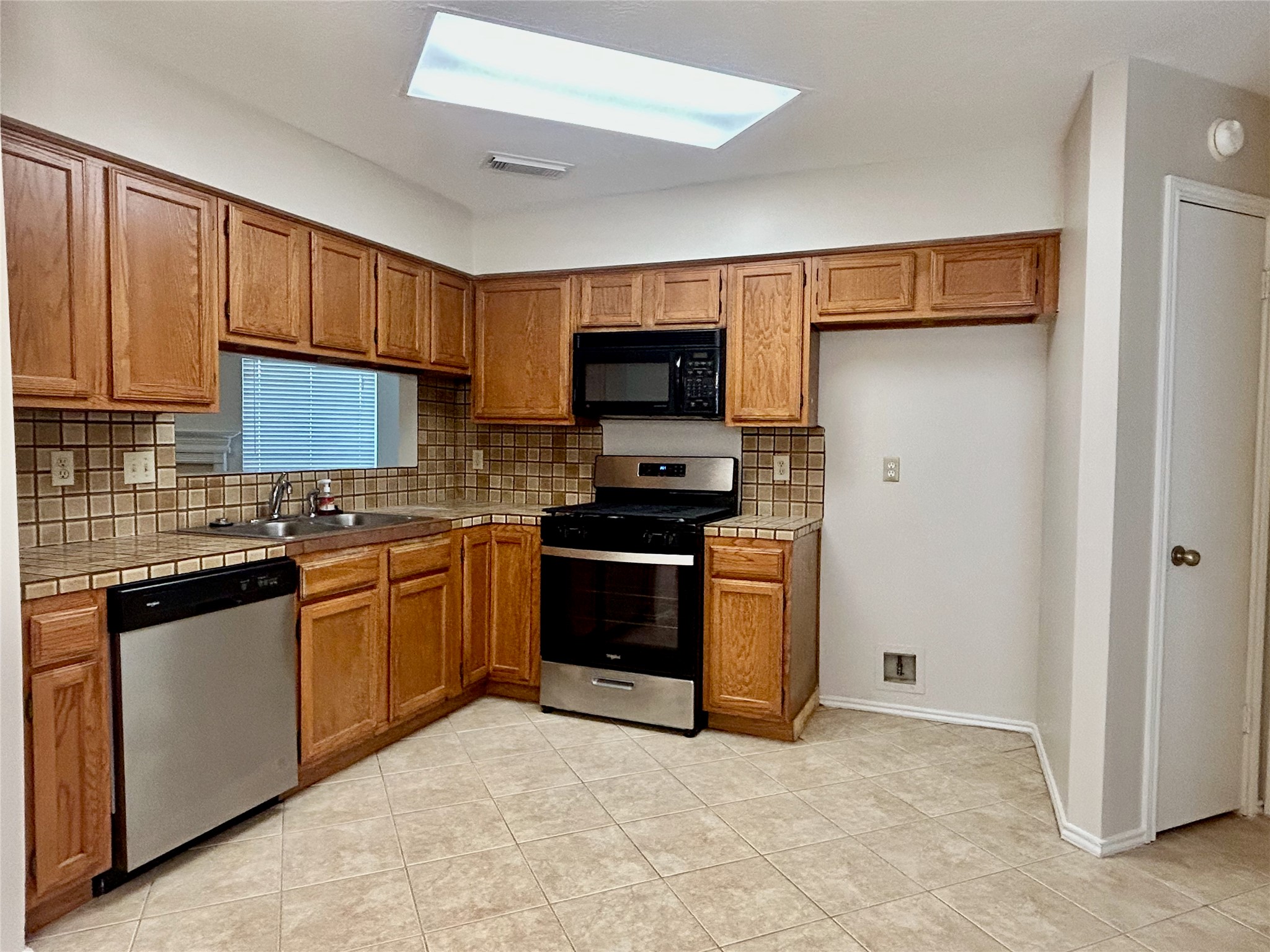 11810 Stone Bridge Drive Houston, TX 77064 - Photo 11 of 28 a kitchen with granite countertop a refrigerator and a stove top oven