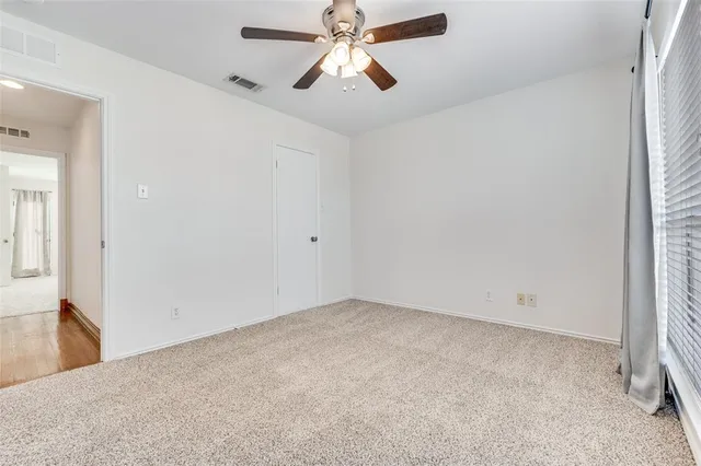 an empty room with chandelier fan