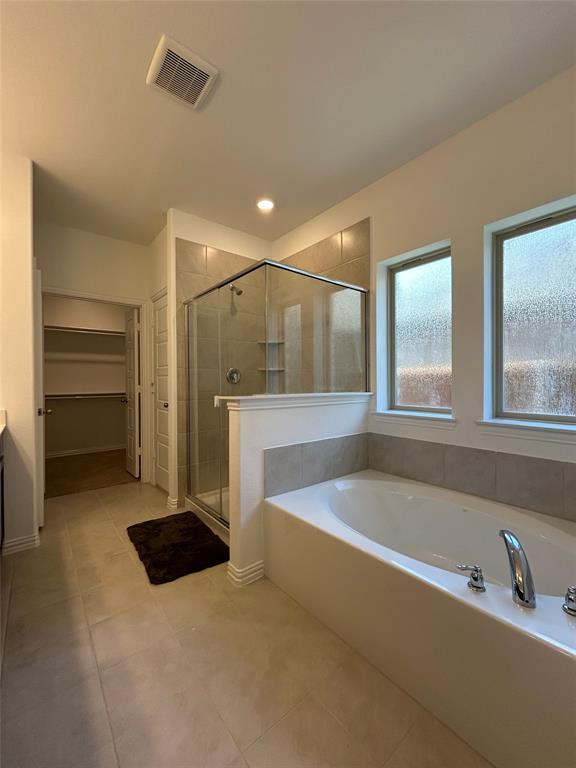 1448 Sun Gdn Way Justin, TX 76247 - Photo 10 of 28 Full bath featuring a spacious closet, vanity, a shower stall, a garden tub, and light tile patterned floors