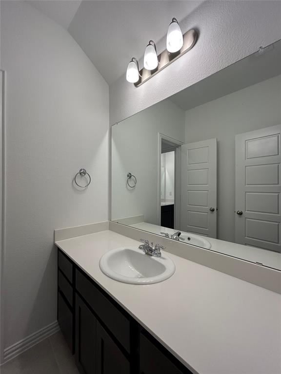 1448 Sun Gdn Way Justin, TX 76247 - Photo 23 of 28 Bathroom with vanity and dark tile patterned floors