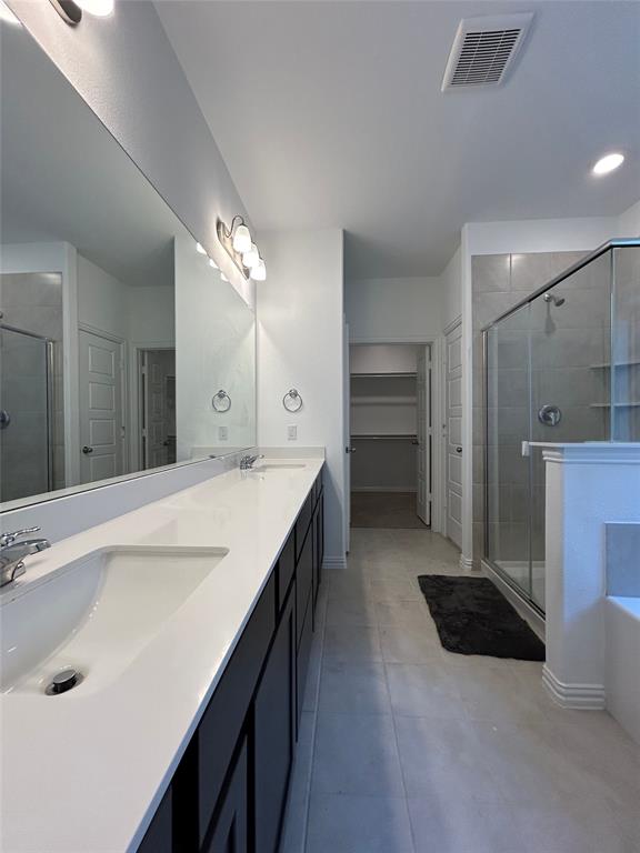 1448 Sun Gdn Way Justin, TX 76247 - Photo 24 of 28 Full bath featuring a stall shower, double vanity, a bath, and a walk in closet
